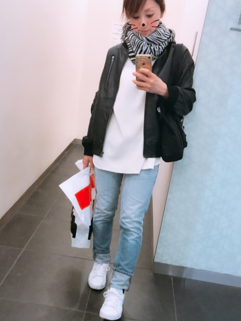 ホワイト系のTシャツ/カットソー、ブルー系のデニムパンツ、ホワイト系のスニーカーを着用したレディースの秋コーディネートの1枚目の写真