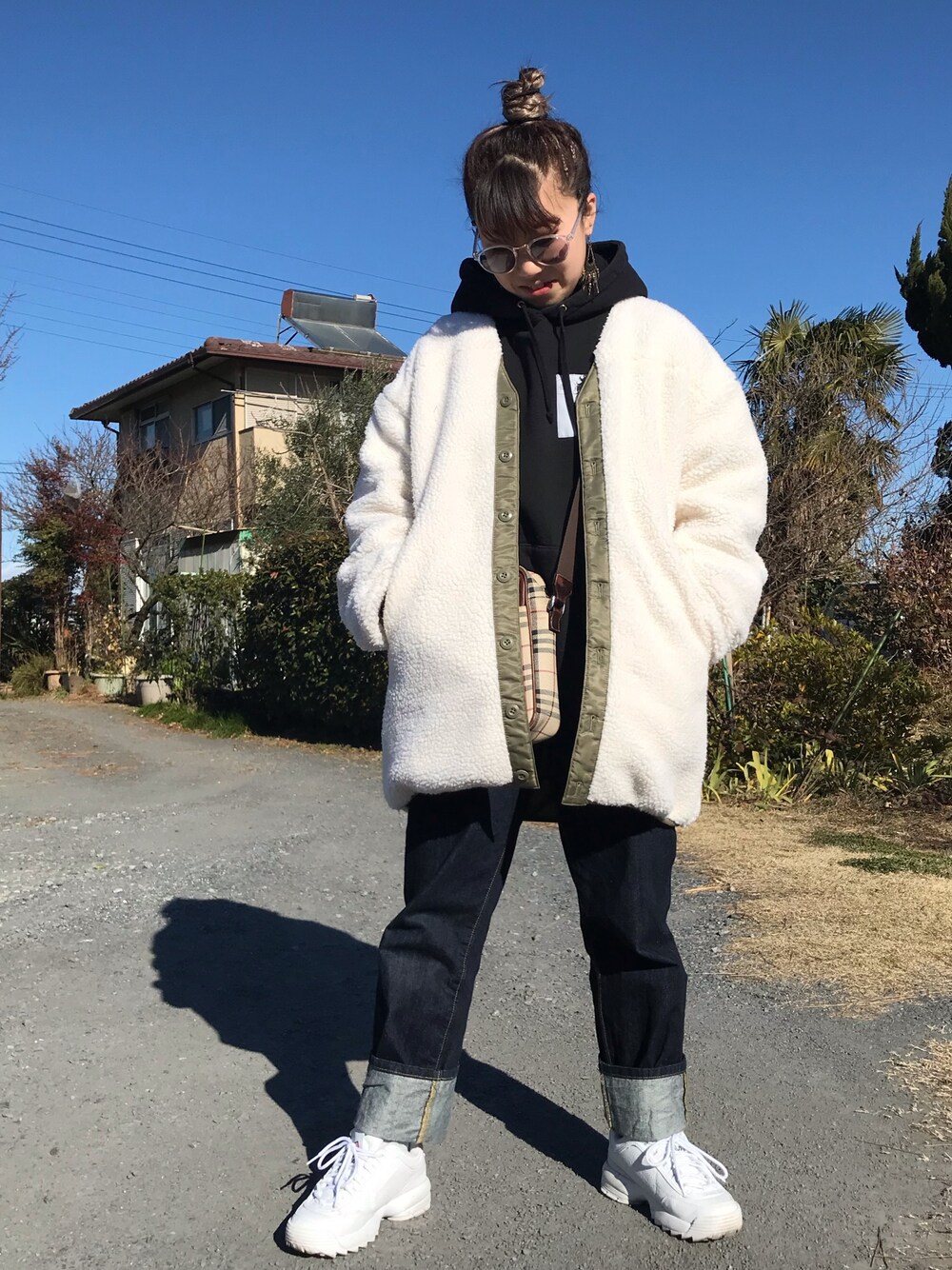 ベージュ系のノーカラージャケット、ブルー系のデニムパンツを着用したレディースの冬コーディネートの1枚目の写真