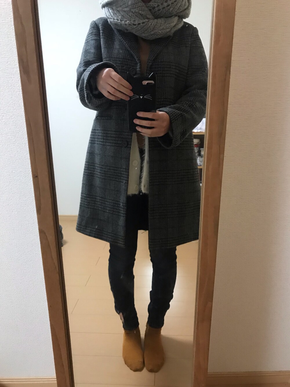 グレー系のチェスターコートを着用したレディースの秋コーディネートの1枚目の写真