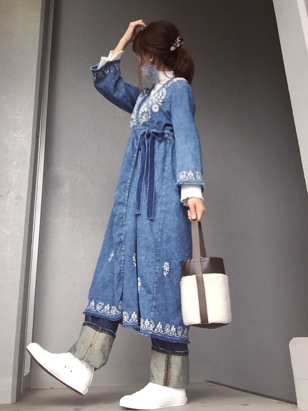 ブルー系のワンピース、ホワイト系のニット/セーター、ブルー系のデニムパンツを着用したレディースの冬コーディネートの1枚目の写真