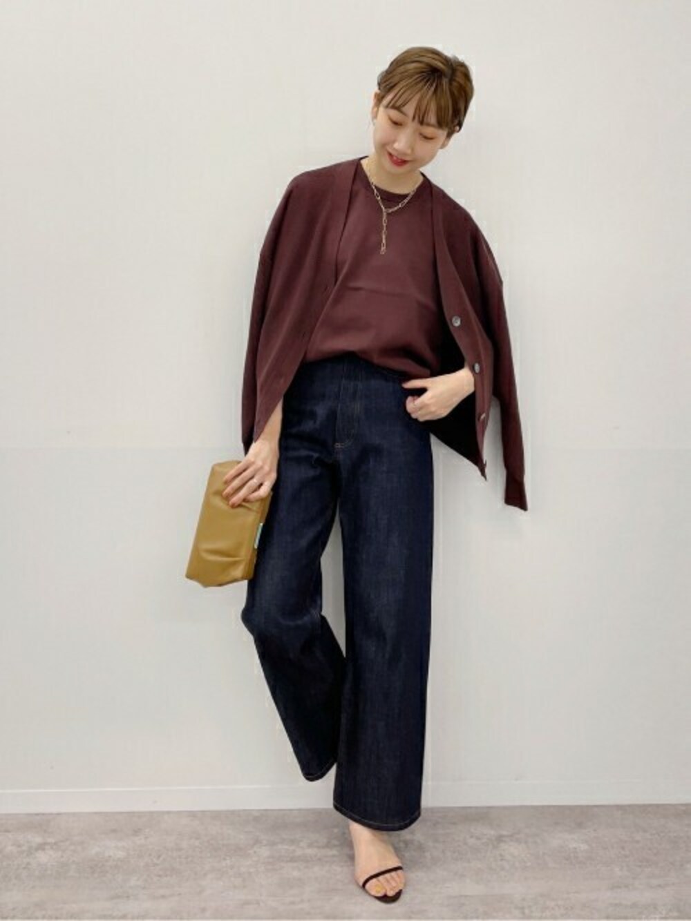 ブラウン系のニット/セーター、ブラウン系のニット/セーター、ブルー系のデニムパンツを着用したレディースの夏コーディネートの1枚目の写真