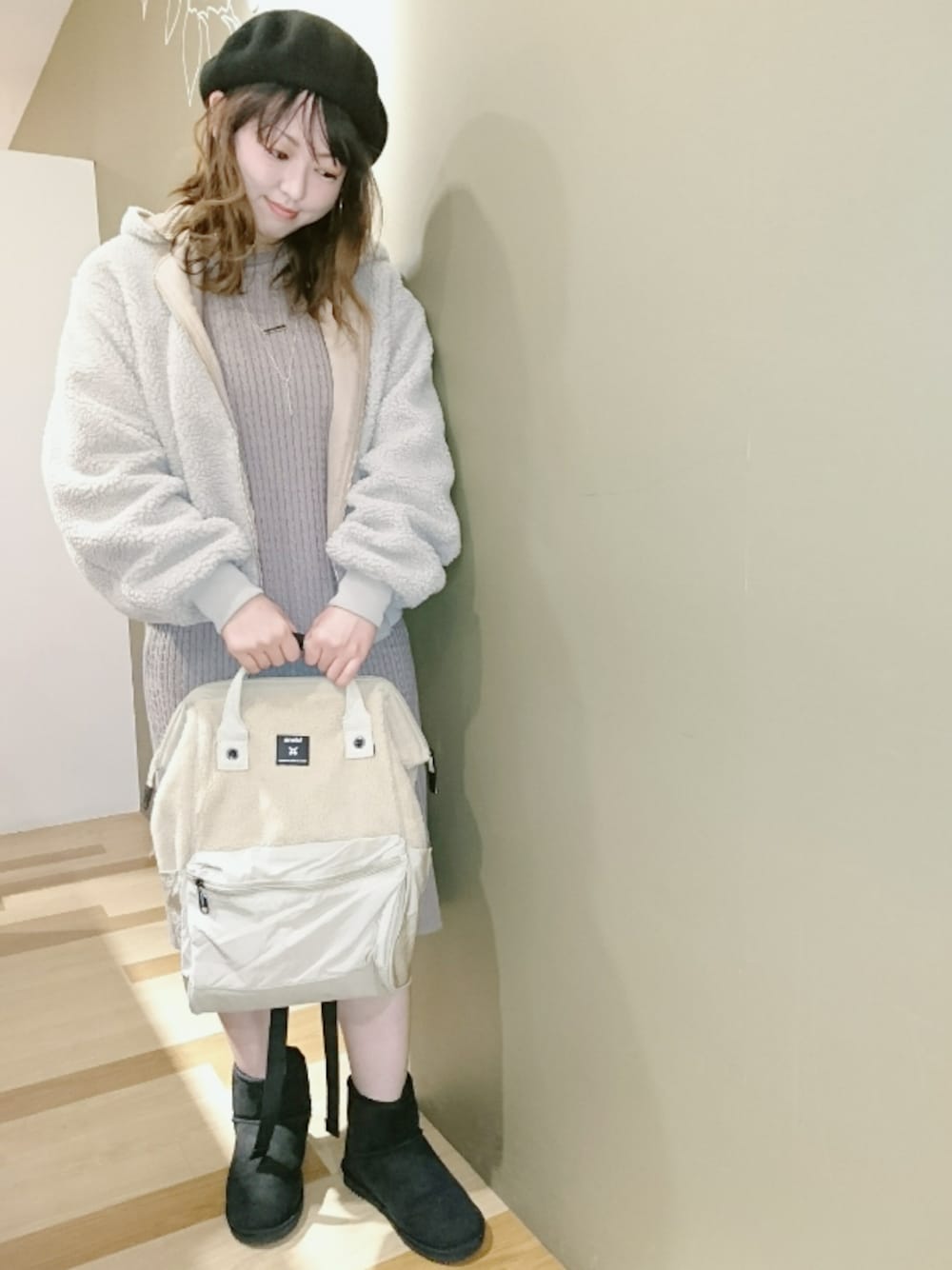 ベージュ系のブルゾン、ベージュ系のワンピース、ホワイト系のバックパック/リュックを着用したレディースの冬コーディネートの1枚目の写真