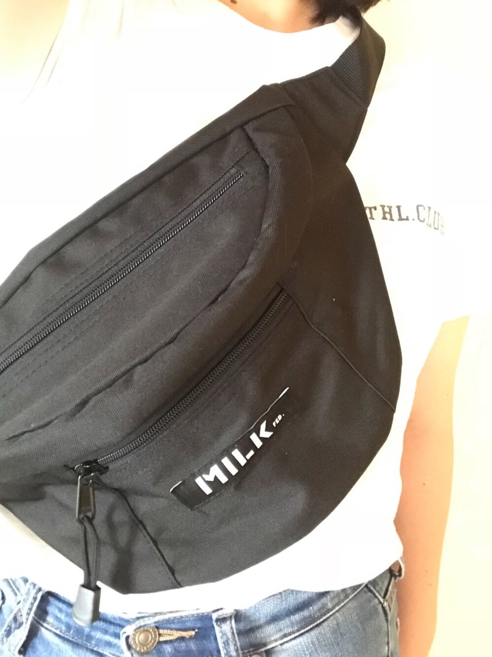 ブラック系のボディバッグ/ウエストポーチ、ホワイト系のTシャツ/カットソー、ブルー系のデニムパンツを着用したレディースの夏コーディネートの1枚目の写真