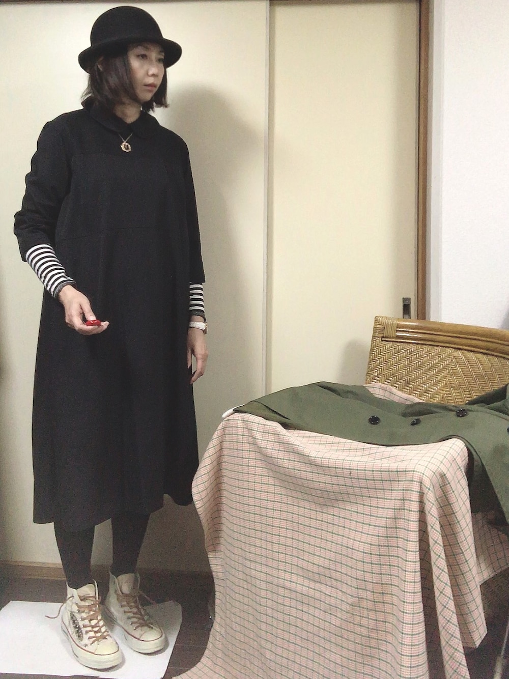 ブラック系のワンピース、ホワイト系のTシャツ/カットソー、ベージュ系のスニーカーを着用したレディースの冬コーディネートの1枚目の写真