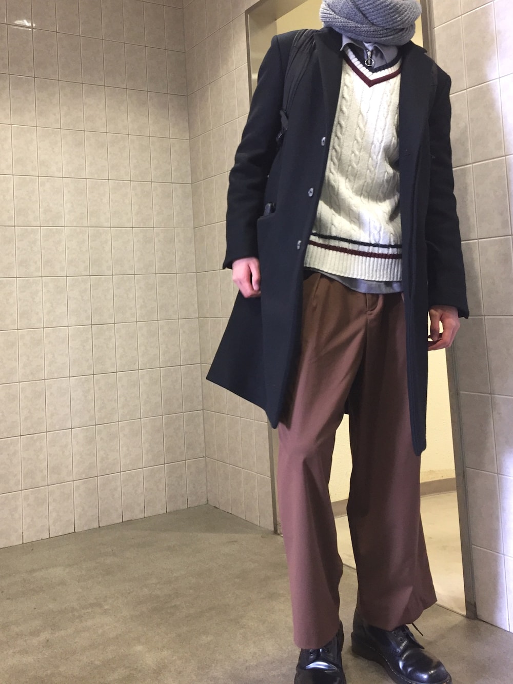 ブラック系のチェスターコート、グレー系のシャツ/ブラウス、ホワイト系のTシャツ/カットソーを着用したメンズの冬コーディネートの1枚目の写真