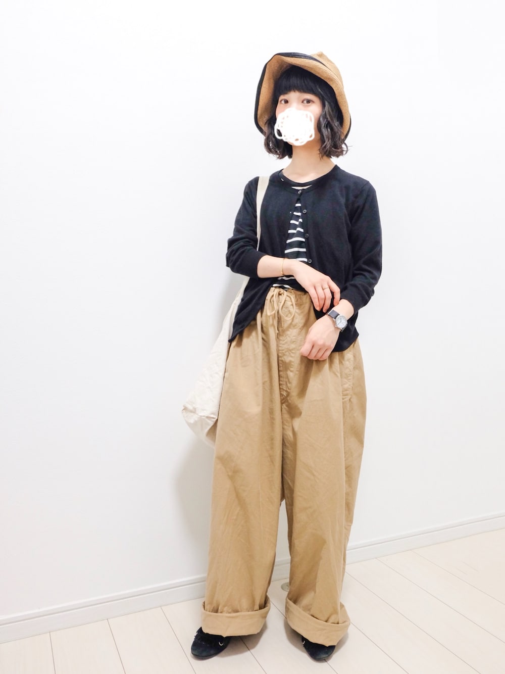 ブラック系のカーディガン/ボレロ、ブラック系のTシャツ/カットソー、ベージュ系のパンツを着用したレディースの春コーディネートの1枚目の写真