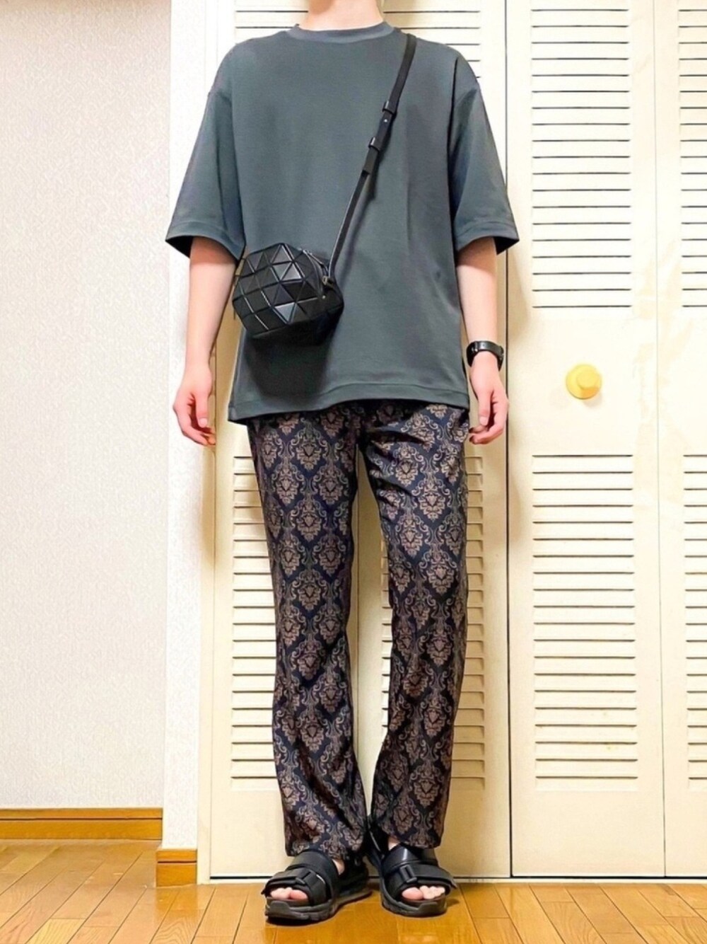 グレー系のTシャツ/カットソー、ブラウン系のその他パンツ、ブラック系のサンダルを着用したメンズの春コーディネートの1枚目の写真