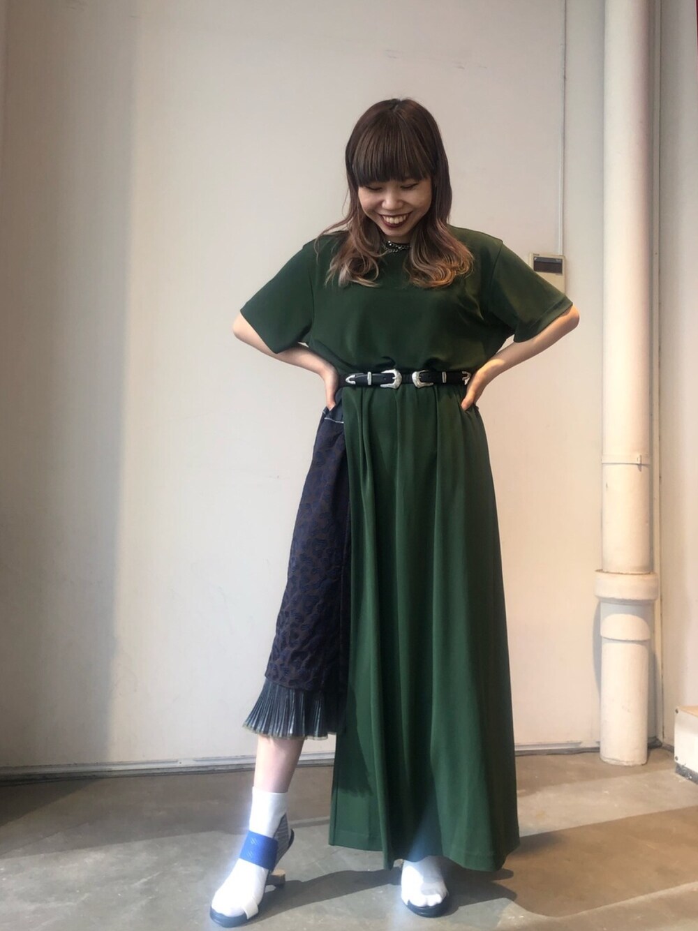 グリーン系のワンピース、ブラウン系のスカート、ホワイト系のシューズを着用したレディースの夏コーディネートの1枚目の写真