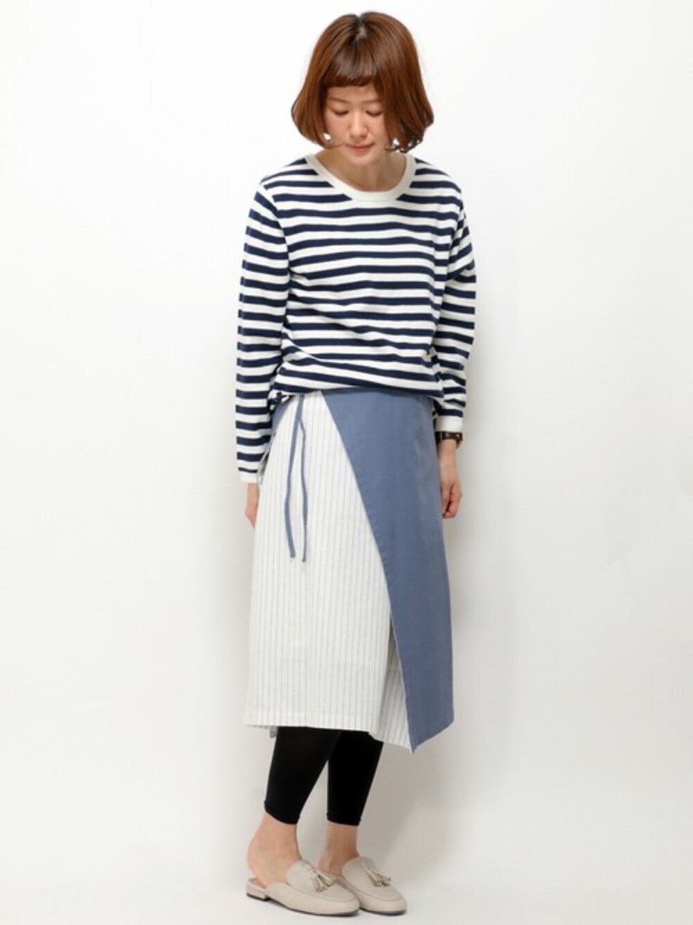 ブルー系のスカート、グレー系のローファーを着用したレディースの春コーディネートの1枚目の写真
