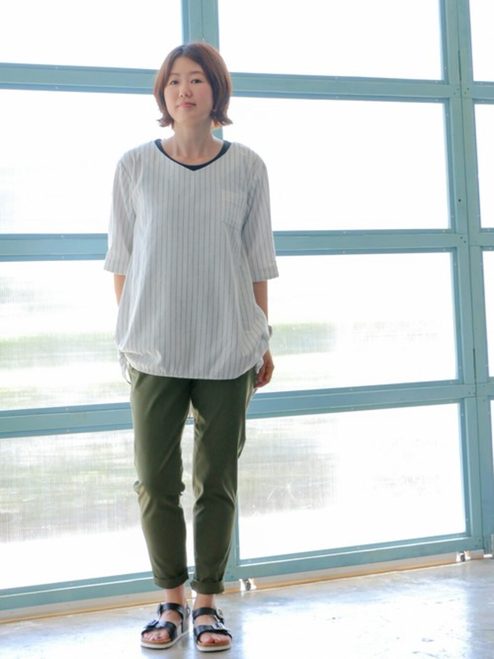 グリーン系のその他パンツ、ホワイト系のシャツ/ブラウス、ブラック系のサンダルを着用したレディースの夏コーディネートの1枚目の写真