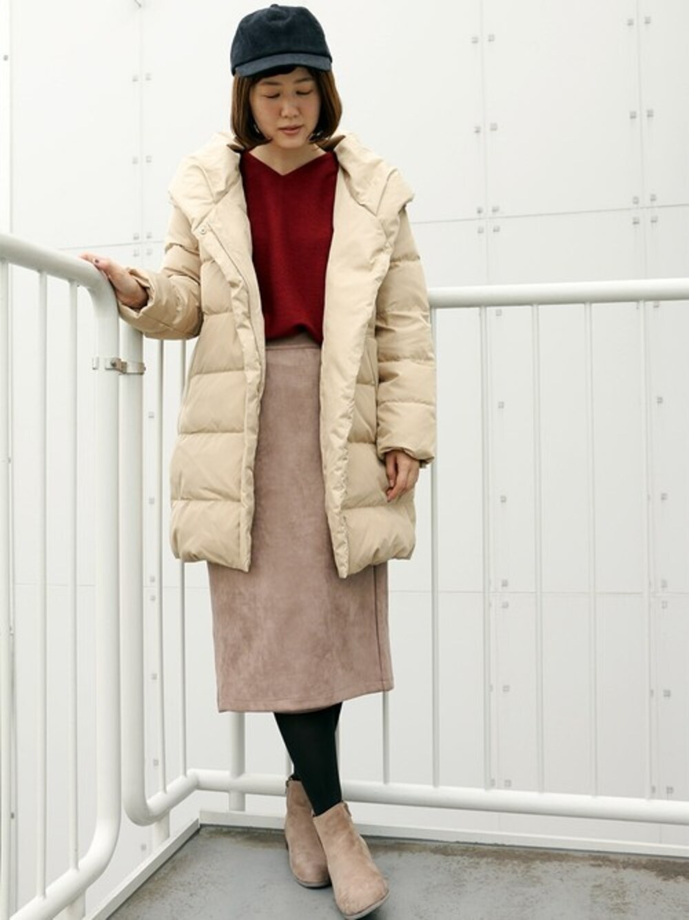 ベージュ系のダウンジャケット/コート、レッド系のTシャツ/カットソー、ベージュ系のスカートを着用したレディースの秋コーディネートの1枚目の写真