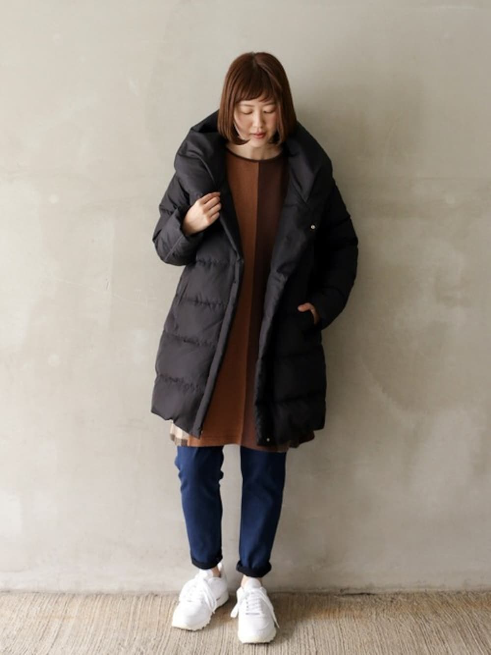 ブラック系のダウンジャケット/コート、ブラウン系のワンピース、ブルー系のその他パンツを着用したレディースの冬コーディネートの1枚目の写真