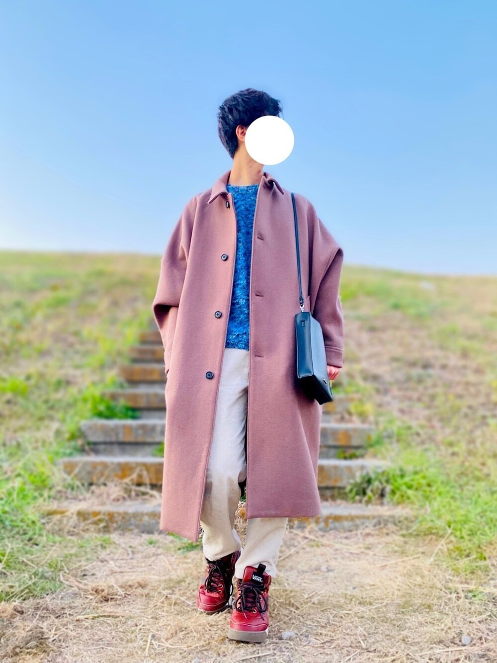 ブラウン系のステンカラーコート、ブルー系のニット/セーター、ベージュ系のブルゾンを着用したメンズの冬コーディネートの1枚目の写真