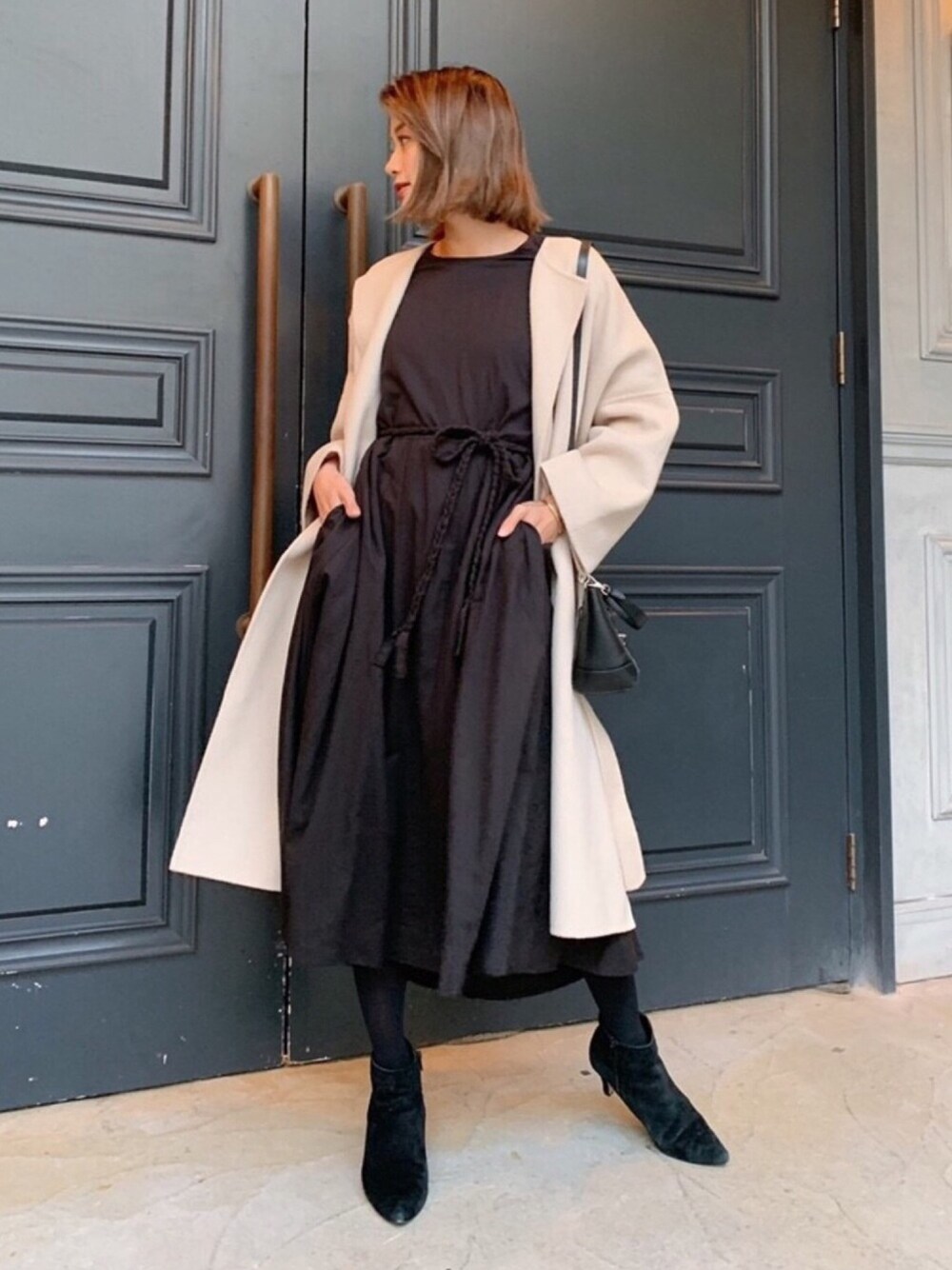 ベージュ系のダウンジャケット/コート、ブラック系のワンピースを着用したレディースの冬コーディネートの1枚目の写真