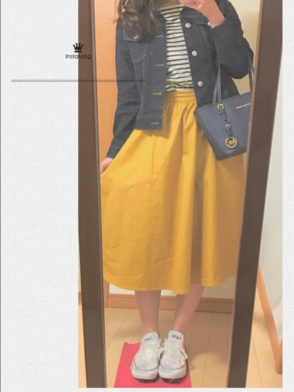 ブラック系のワンピース、ブルー系のデニムジャケット、イエロー系のスカートを着用したレディースの春コーディネートの1枚目の写真