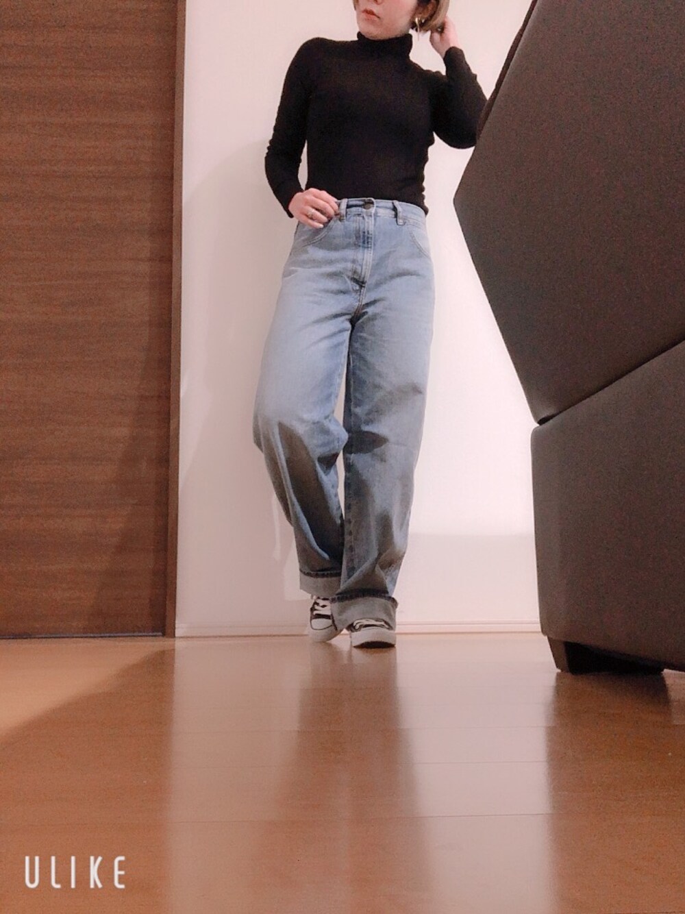 ブラック系のニット/セーター、ブルー系のデニムパンツ、ブラック系のスニーカーを着用したレディースの冬コーディネートの1枚目の写真