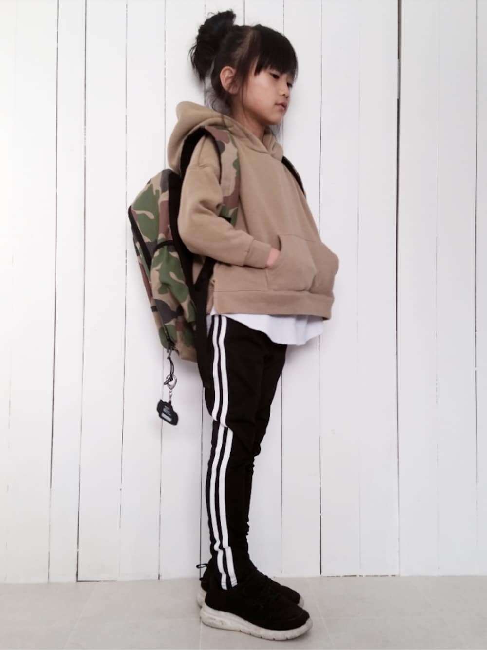 ベージュ系のパーカー、ブラック系のスニーカー、その他のバックパック/リュックを着用したキッズの冬コーディネートの1枚目の写真
