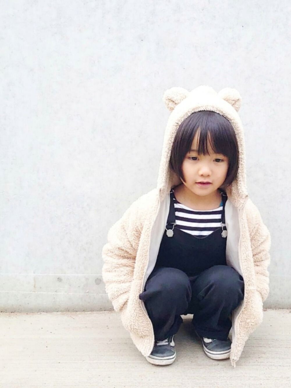 ベージュ系のパーカー、ブラック系のTシャツ/カットソー、ブラック系のスニーカーを着用したキッズの冬コーディネートの1枚目の写真