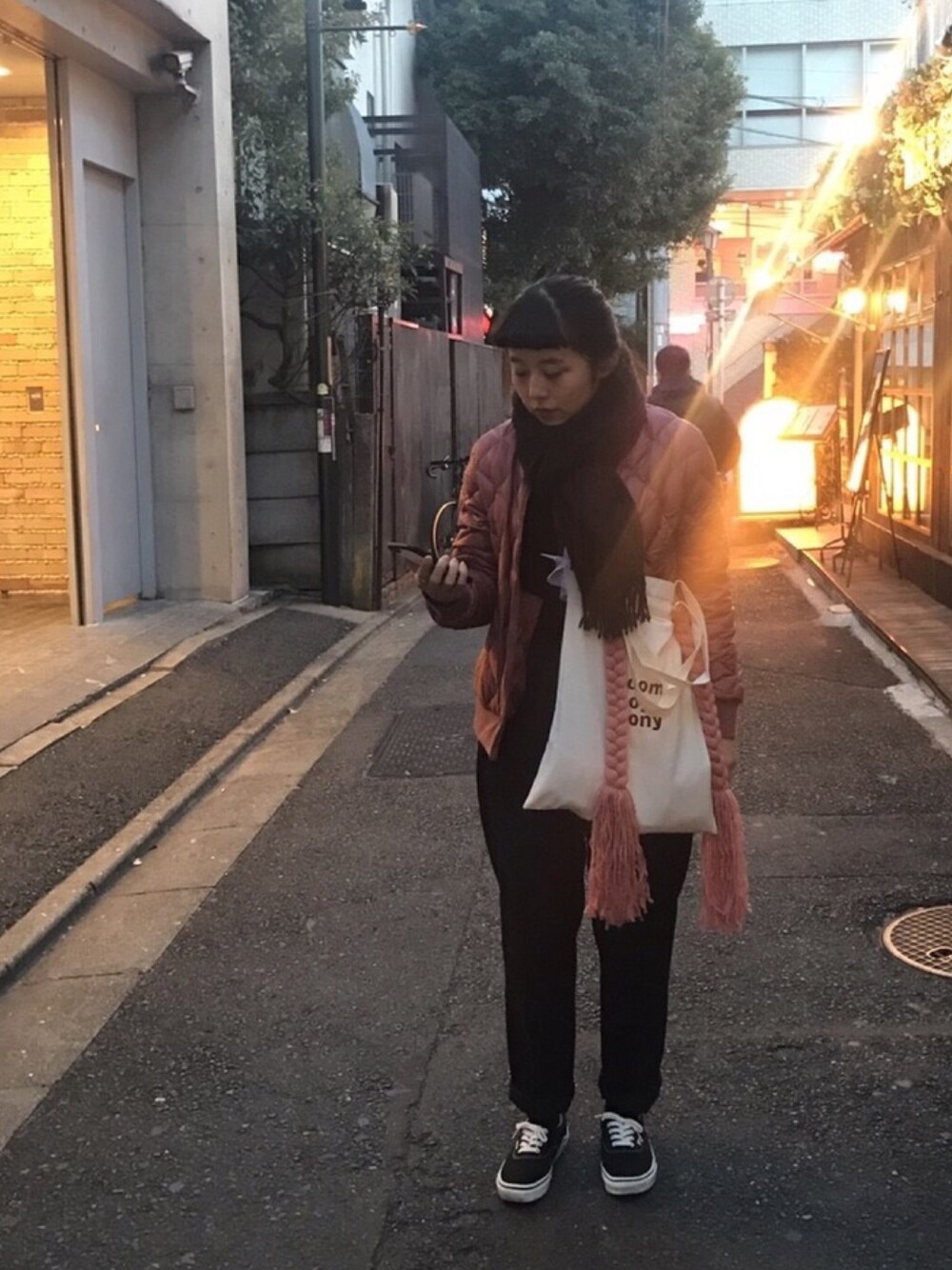 ピンク系のブルゾン、ブラック系のニット/セーター、ブラック系のパンツを着用したレディースの冬コーディネートの1枚目の写真