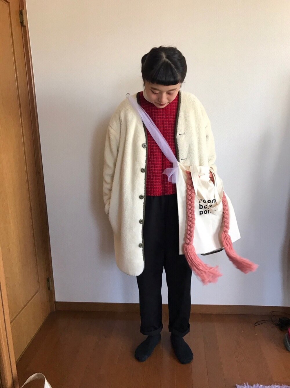 グリーン系のブルゾン、レッド系のベスト、ホワイト系のTシャツ/カットソーを着用したレディースの冬コーディネートの1枚目の写真