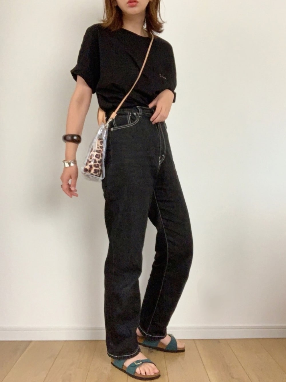 ブラック系のTシャツ/カットソー、ブラック系のデニムパンツ、グリーン系のサンダルを着用したレディースの夏コーディネートの1枚目の写真