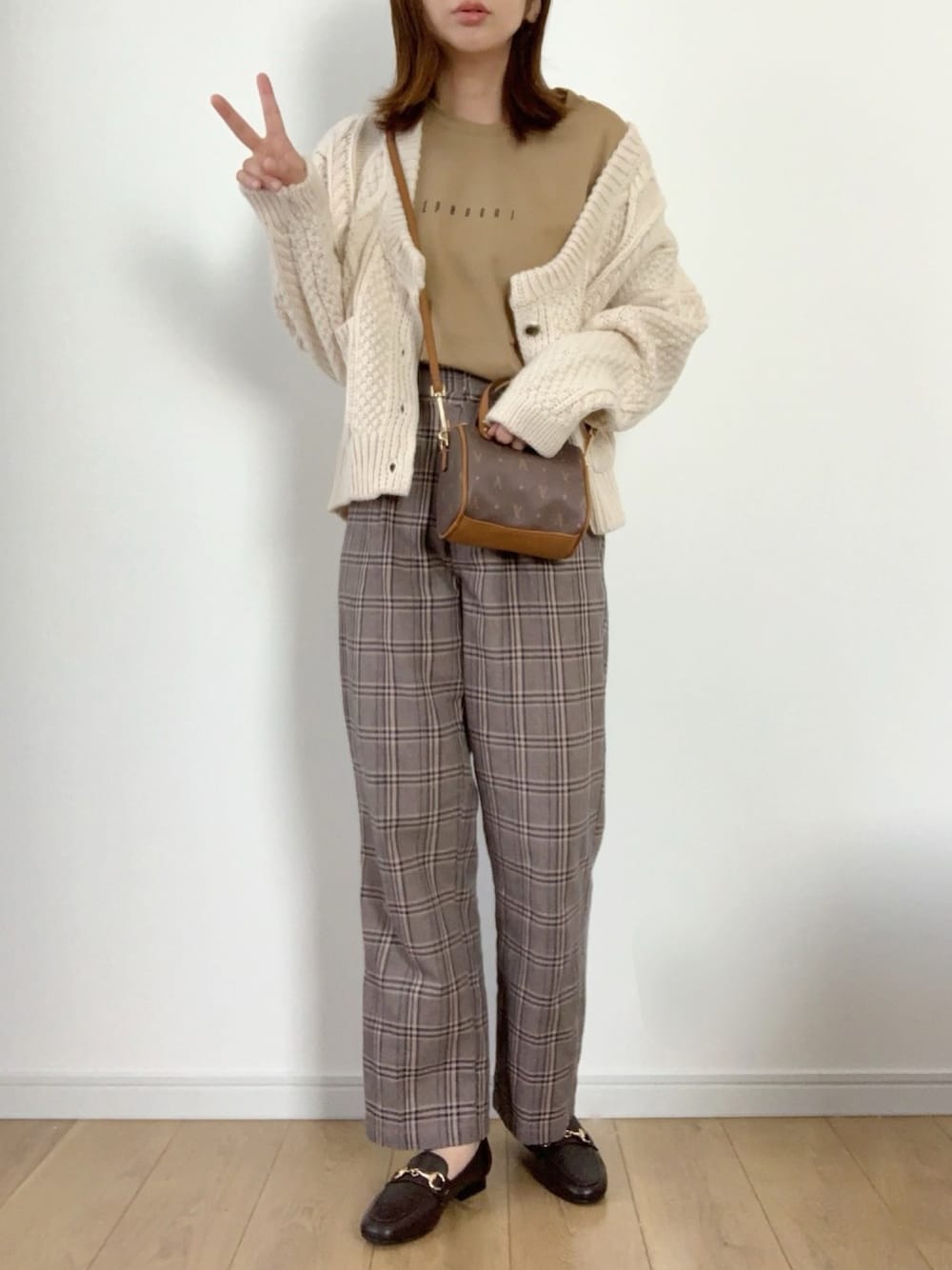 ホワイト系のカーディガン/ボレロ、イエロー系のTシャツ/カットソー、ベージュ系のチノパンツを着用したレディースの秋コーディネートの1枚目の写真