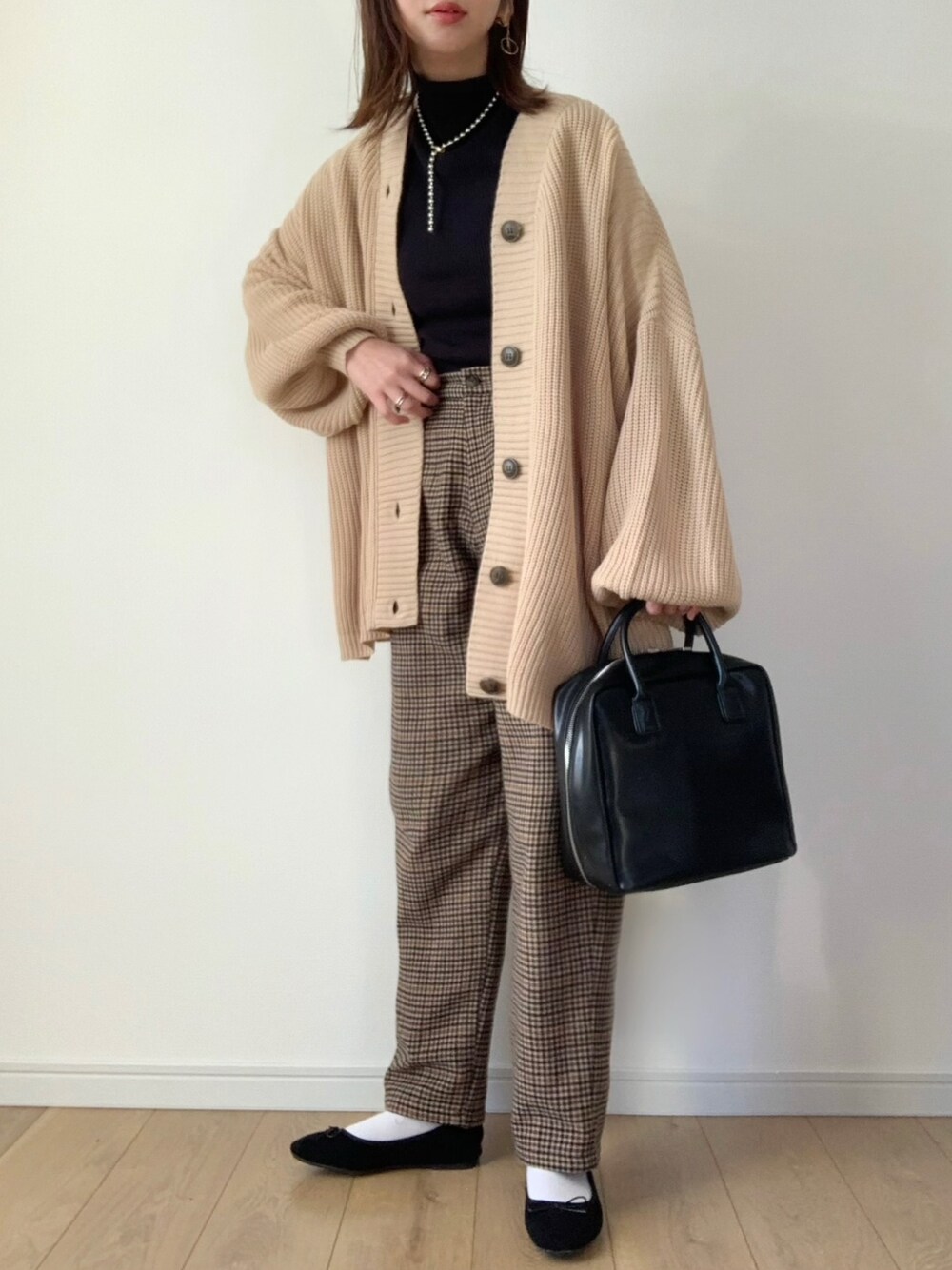 ベージュ系のカーディガン/ボレロ、ブラック系のTシャツ/カットソー、ベージュ系のその他パンツを着用したレディースの冬コーディネートの1枚目の写真