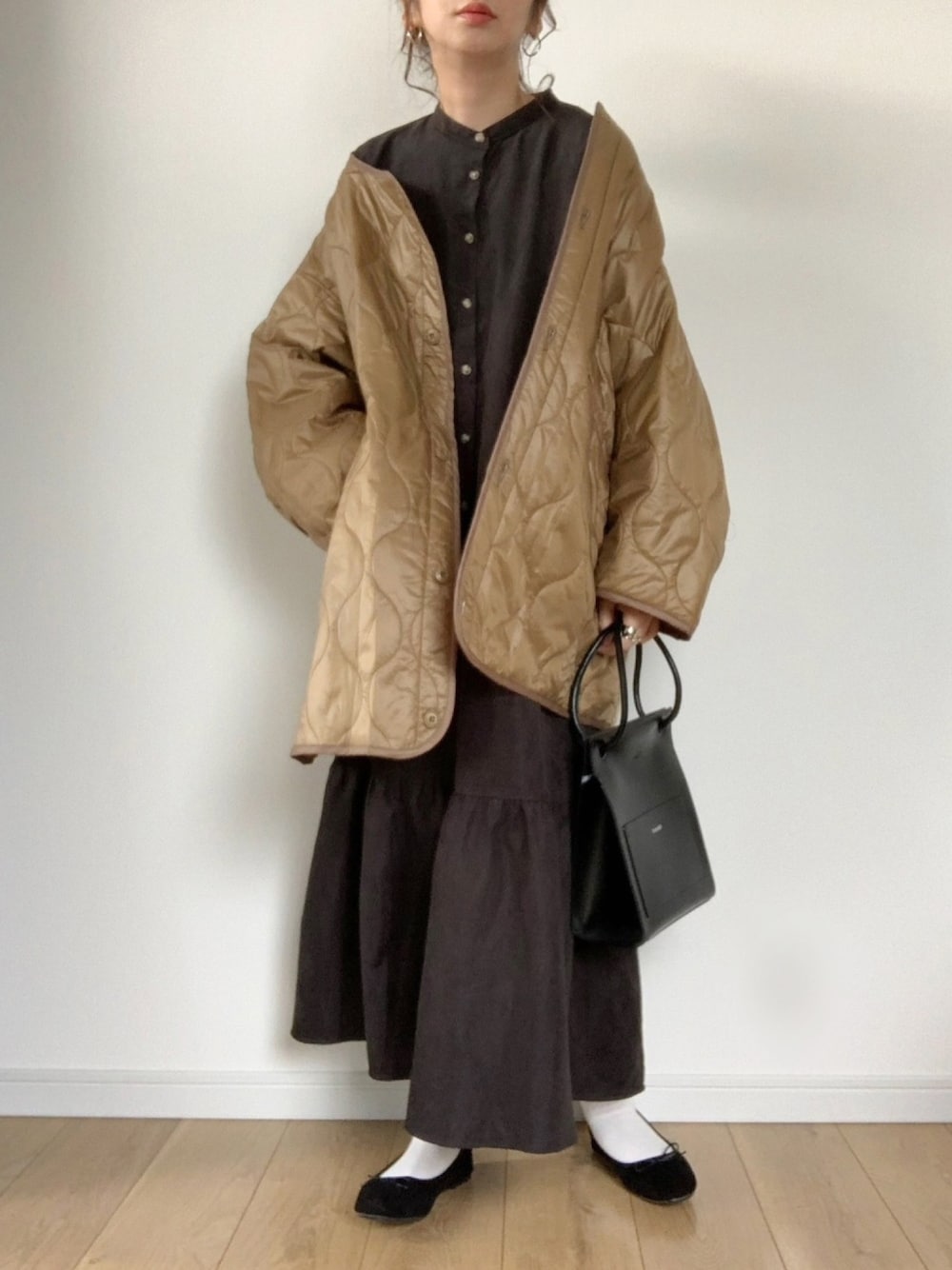 ベージュ系のノーカラージャケット、ブラック系のシャツワンピース、ブラウン系のバレエシューズを着用したレディースの冬コーディネートの1枚目の写真