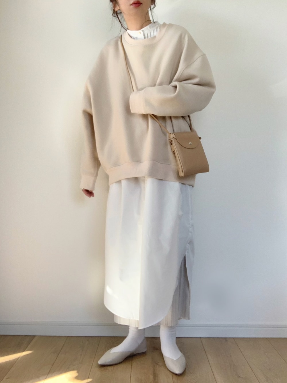 ベージュ系のシャツワンピース、ベージュ系のスウェット、ホワイト系のその他シューズを着用したレディースの冬コーディネートの1枚目の写真