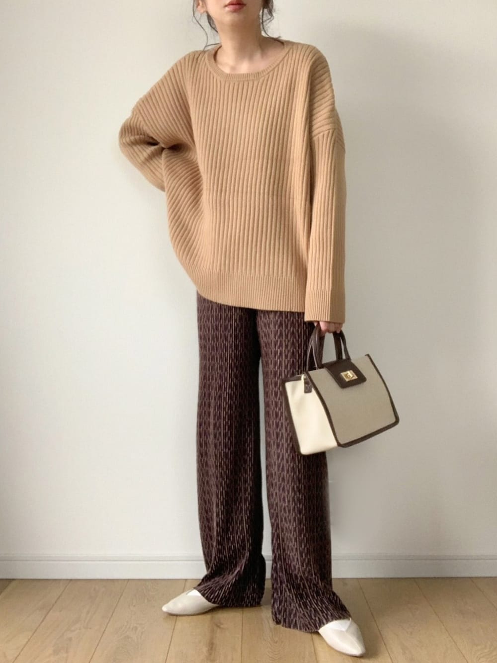 ベージュ系のニット/セーター、ブラウン系のその他パンツ、ホワイト系のその他シューズを着用したレディースの冬コーディネートの1枚目の写真