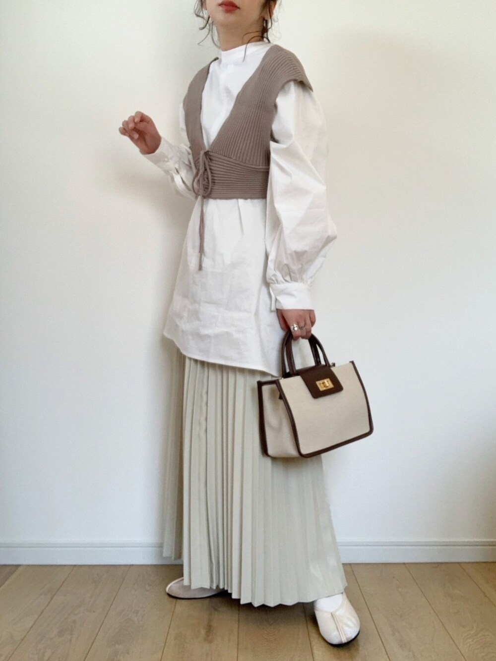 ホワイト系のシャツ/ブラウス、ベージュ系のワンピース、ホワイト系のスカートを着用したレディースの冬コーディネートの1枚目の写真