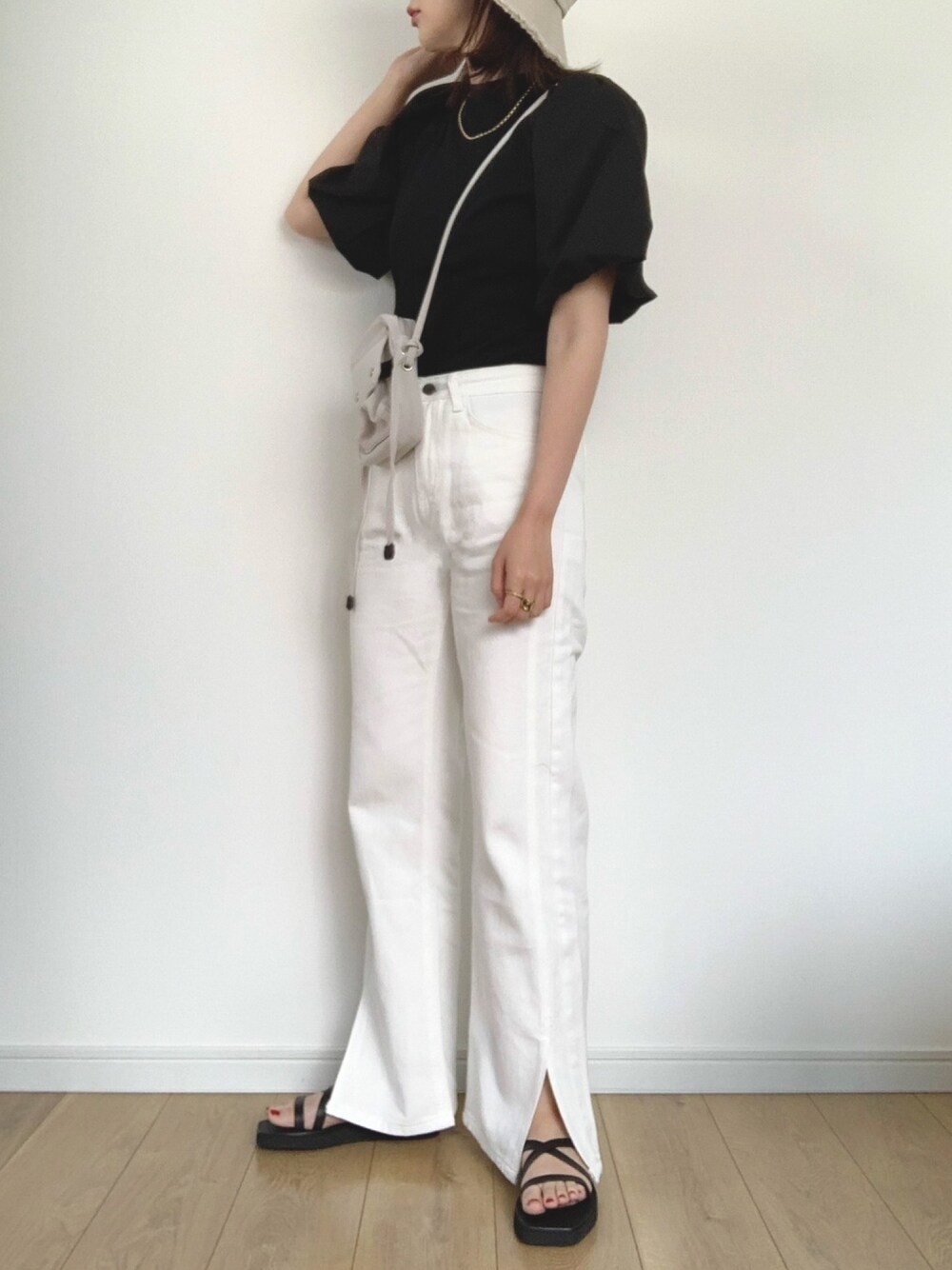 ブラック系のTシャツ/カットソー、ホワイト系のデニムパンツ、ブラック系のサンダルを着用したレディースの春コーディネートの1枚目の写真