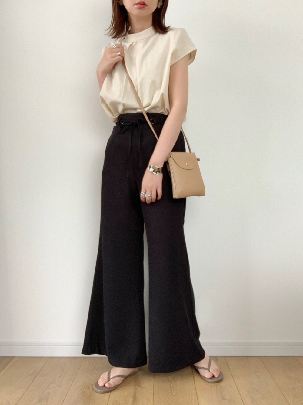 ベージュ系のシャツ/ブラウス、ベージュ系のサンダル、イエロー系のトートバッグを着用したレディースの夏コーディネートの1枚目の写真