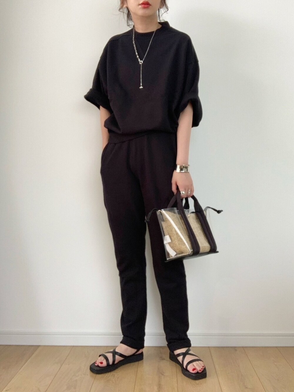 ブラック系のサンダル、ベージュ系のハンドバッグ、ブラック系のルームウェア/パジャマを着用したレディースの夏コーディネートの1枚目の写真