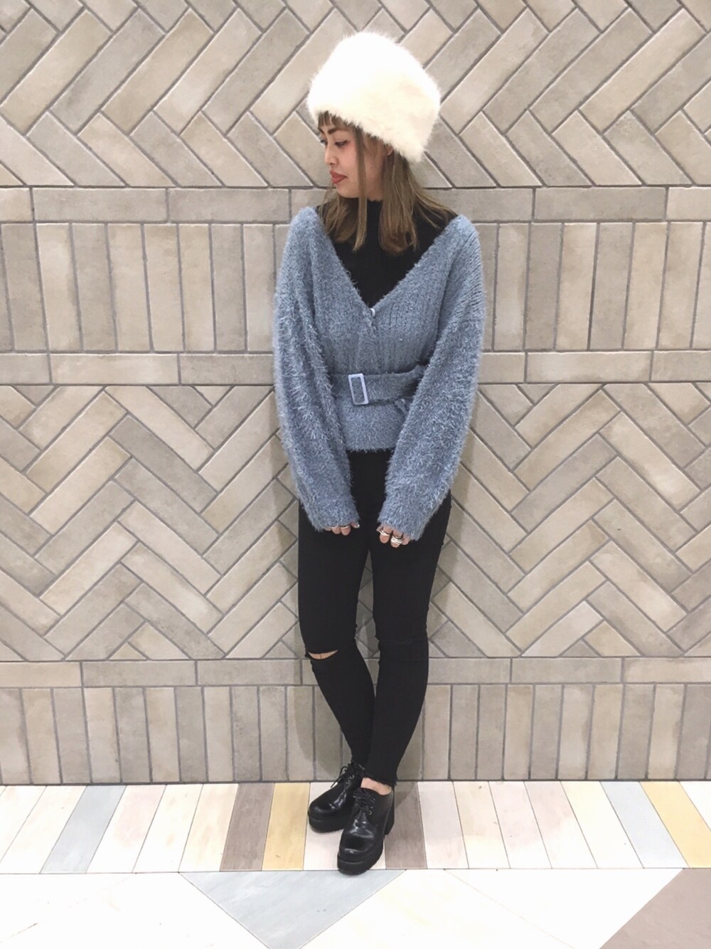 ブルー系のカーディガン/ボレロ、ブラック系のその他パンツ、ホワイト系のハンチング/ベレー帽を着用したレディースの冬コーディネートの1枚目の写真