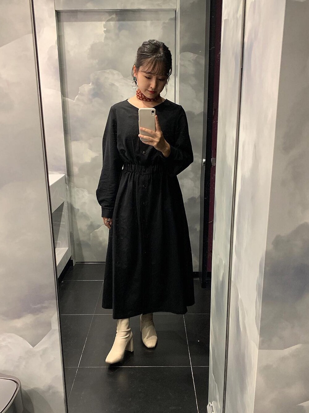 ブラック系のワンピース、ホワイト系のブーツ、レッド系のネックレスを着用したレディースの秋コーディネートの1枚目の写真