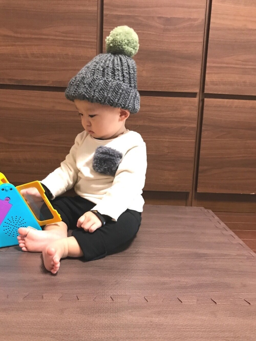 ホワイト系のトップス、ブラック系のパンツ、グレー系の帽子を着用したキッズの秋コーディネートの1枚目の写真