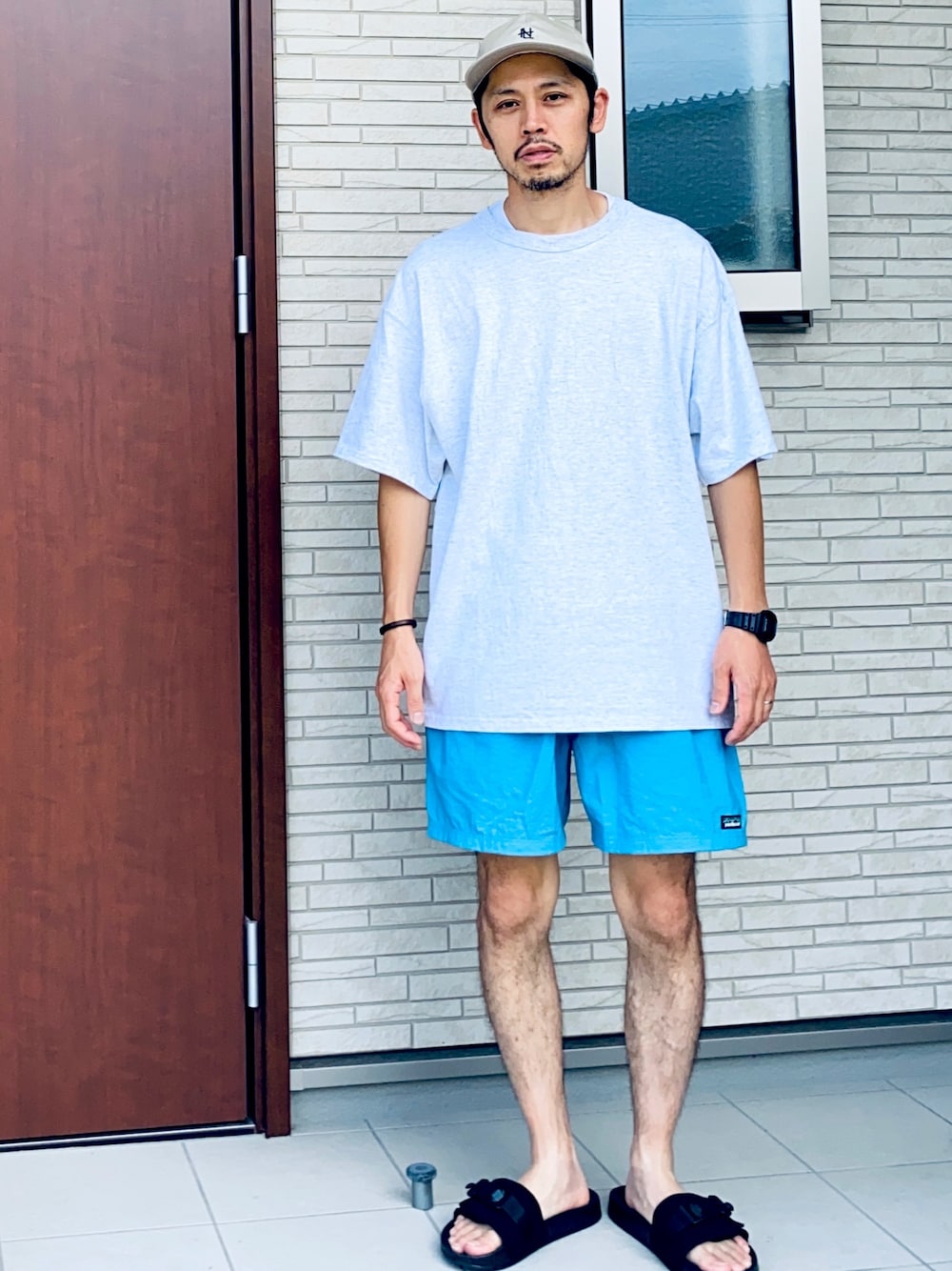 シルバー系のTシャツ/カットソー、ブルー系のパンツ、ブラック系のサンダルを着用したメンズの夏コーディネートの1枚目の写真