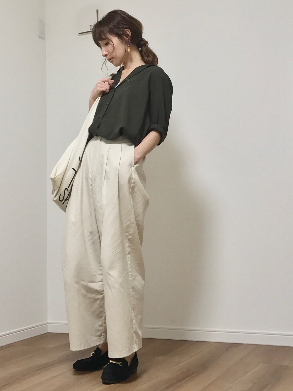 グリーン系のシャツ/ブラウス、ベージュ系のパンツ、ホワイト系のエコバッグ/サブバッグを着用したレディースの春コーディネートの1枚目の写真