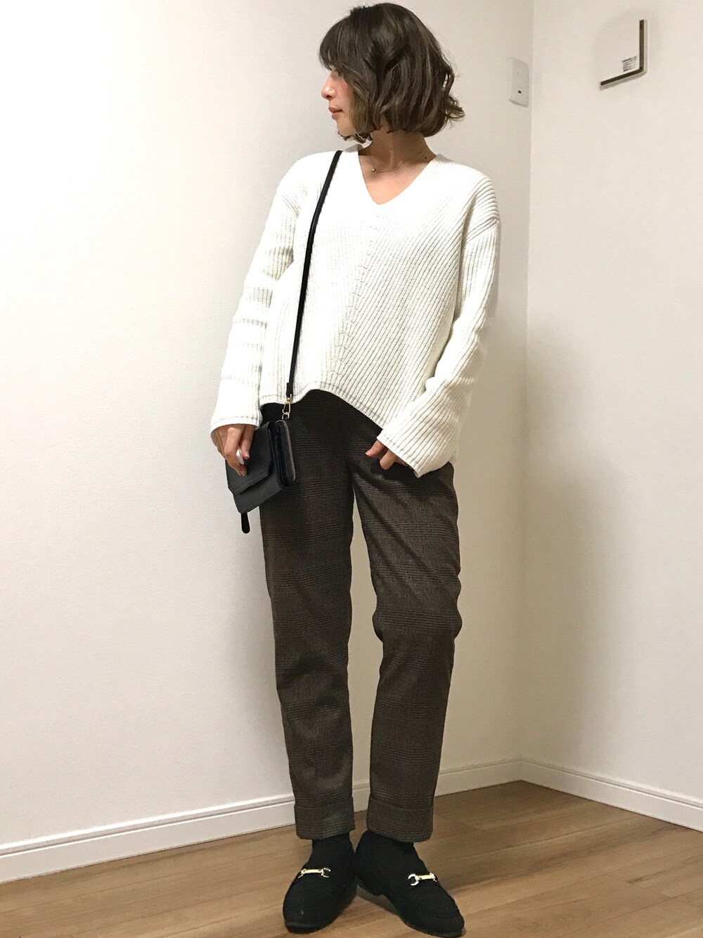 ホワイト系のニット/セーター、ブラウン系のその他パンツ、ブラック系のショルダーバッグを着用したレディースの冬コーディネートの1枚目の写真