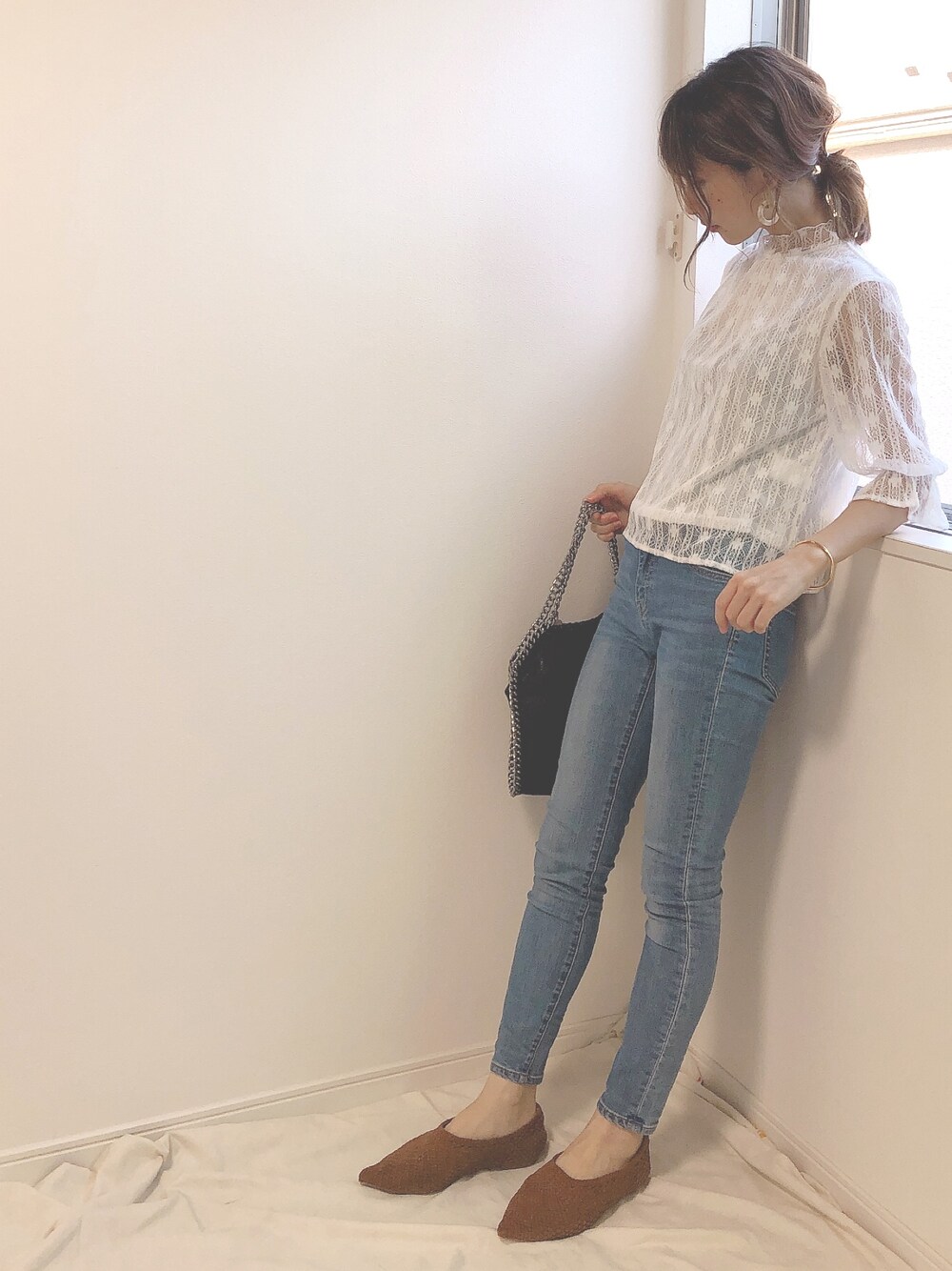ホワイト系のシャツ/ブラウス、ブルー系のデニムパンツ、ブラック系のショルダーバッグを着用したレディースの春コーディネートの1枚目の写真
