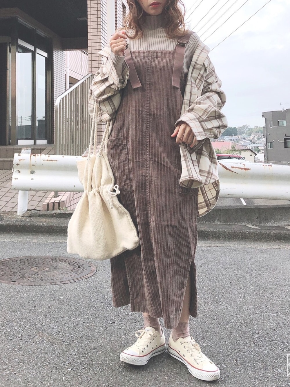 ブラウン系のジャンパースカート、ベージュ系のニット/セーター、ベージュ系のシャツ/ブラウスを着用したレディースの秋コーディネートの1枚目の写真