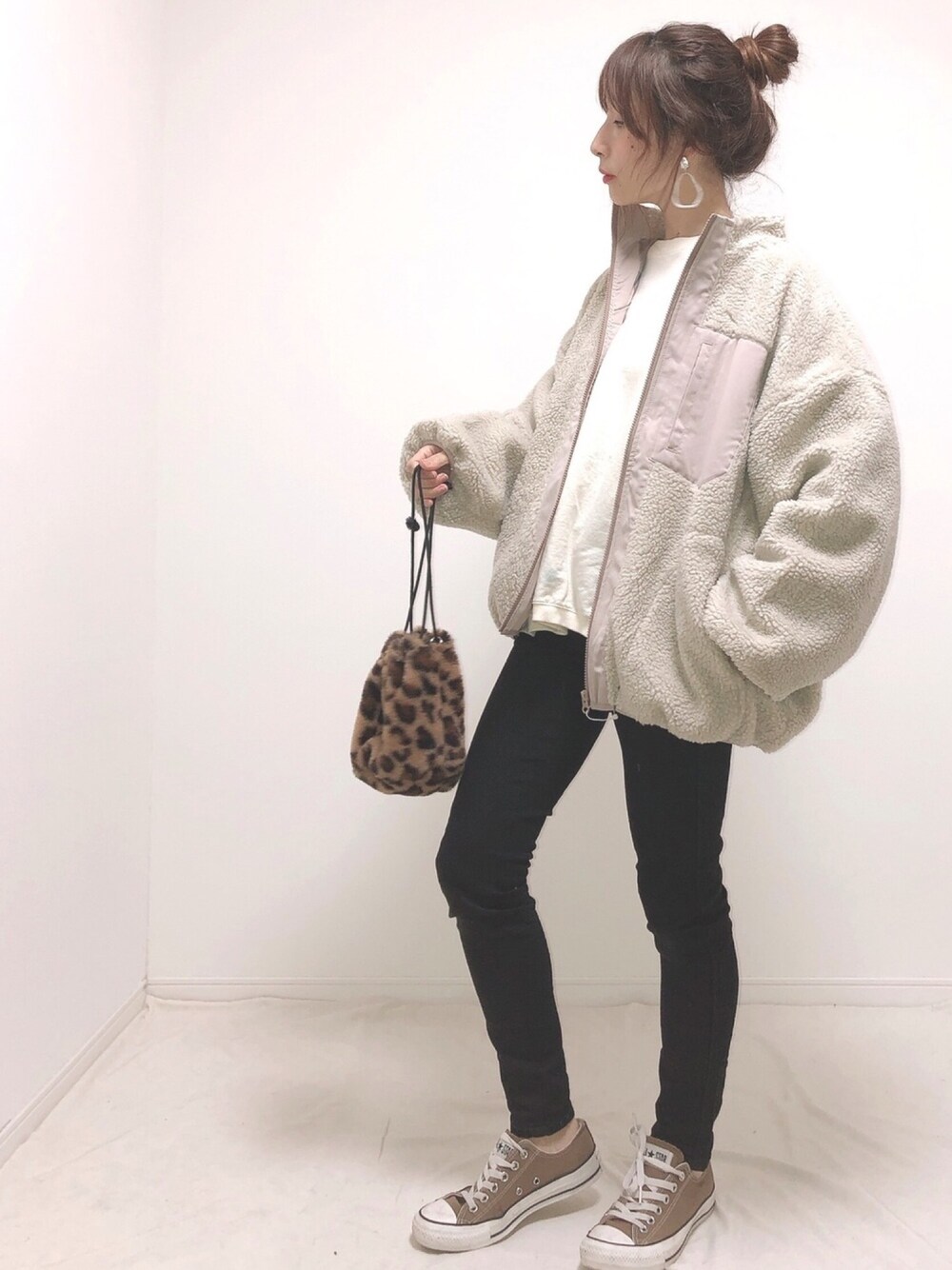 グレー系のブルゾン、ホワイト系のTシャツ/カットソー、ブラック系のパンツを着用したレディースの冬コーディネートの1枚目の写真