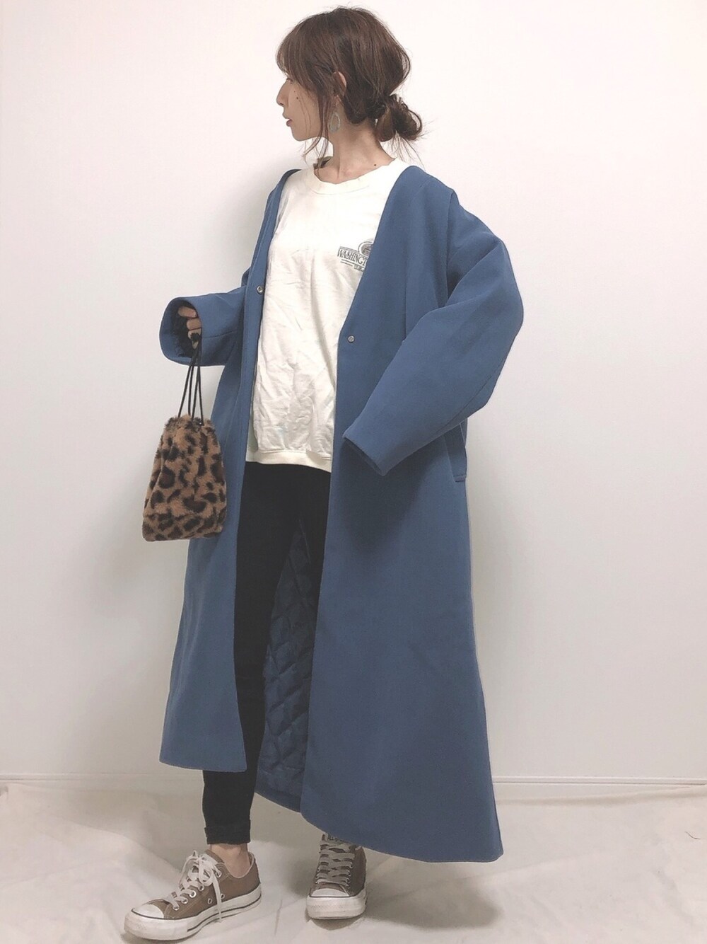 ブルー系のノーカラーコート、ホワイト系のTシャツ/カットソー、ブラック系のデニムパンツを着用したレディースの冬コーディネートの1枚目の写真