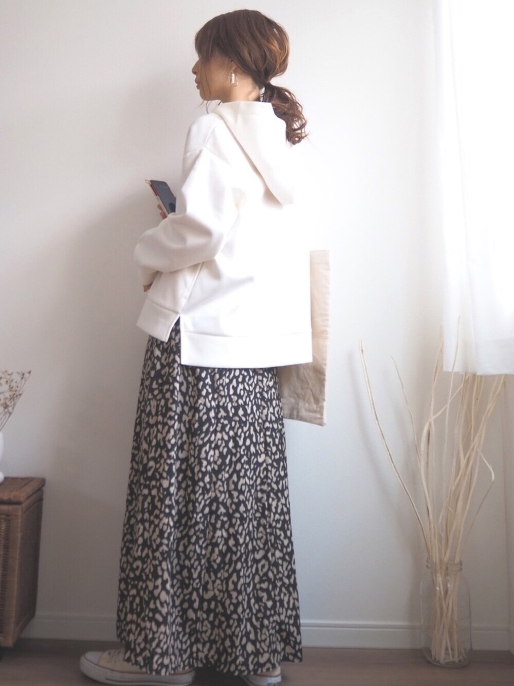 ホワイト系のパーカー、ブラック系のスカート、ベージュ系のエコバッグ/サブバッグを着用したレディースの秋コーディネートの1枚目の写真