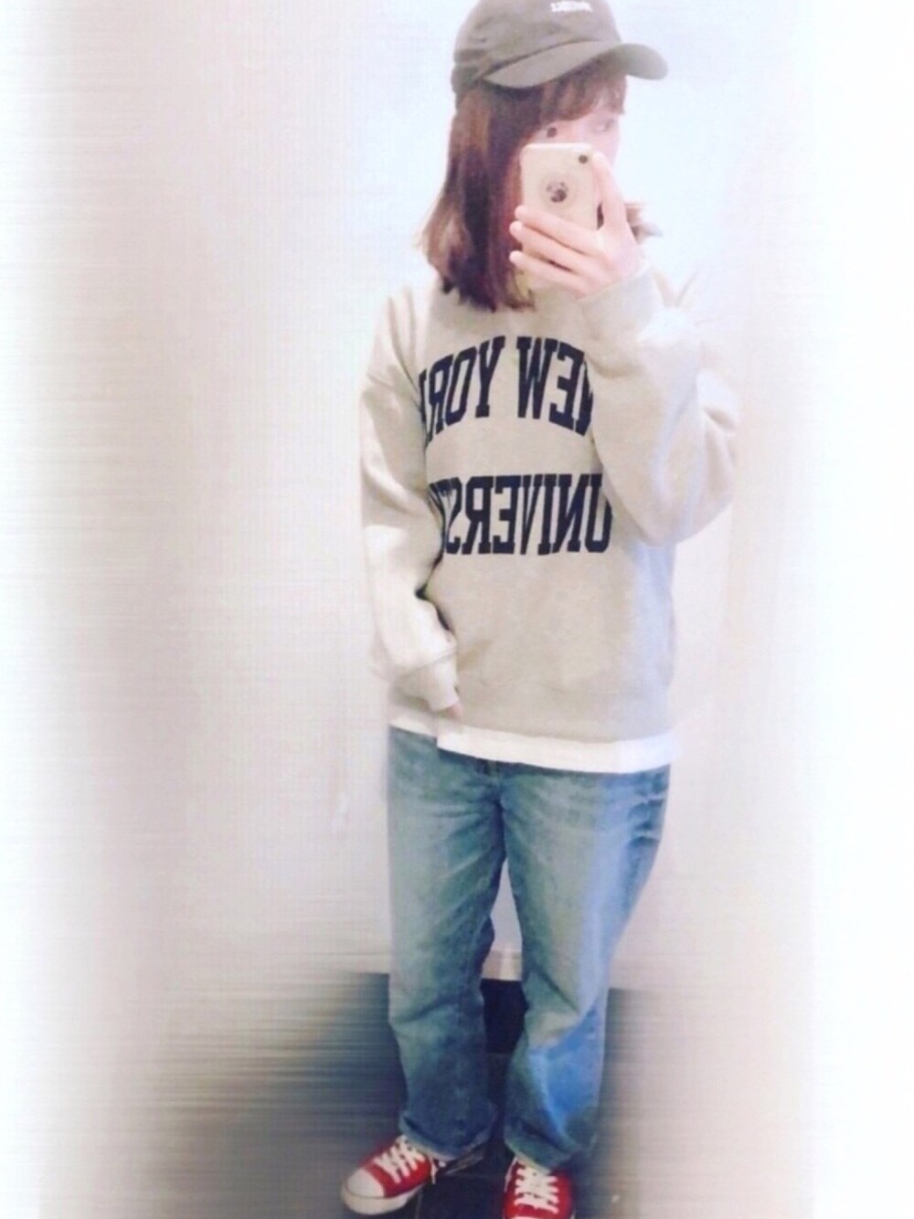 グレー系のパーカー、ブルー系のデニムパンツ、レッド系のスニーカーを着用したレディースの春コーディネートの1枚目の写真