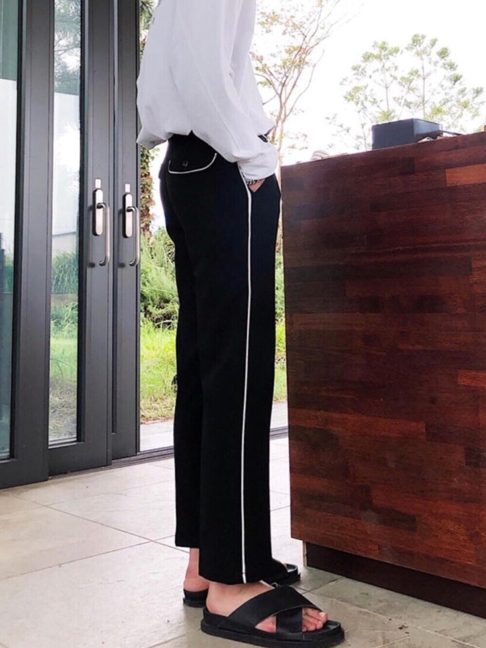 ブラック系のスラックスを着用したメンズの春コーディネートの1枚目の写真