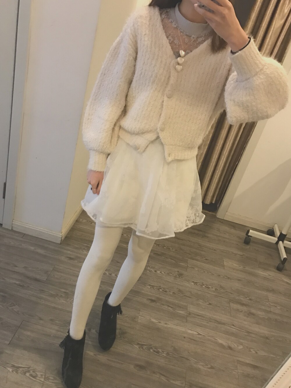 ホワイト系のカーディガン/ボレロ、パープル系のTシャツ/カットソー、ホワイト系のスカートを着用したレディースの冬コーディネートの1枚目の写真