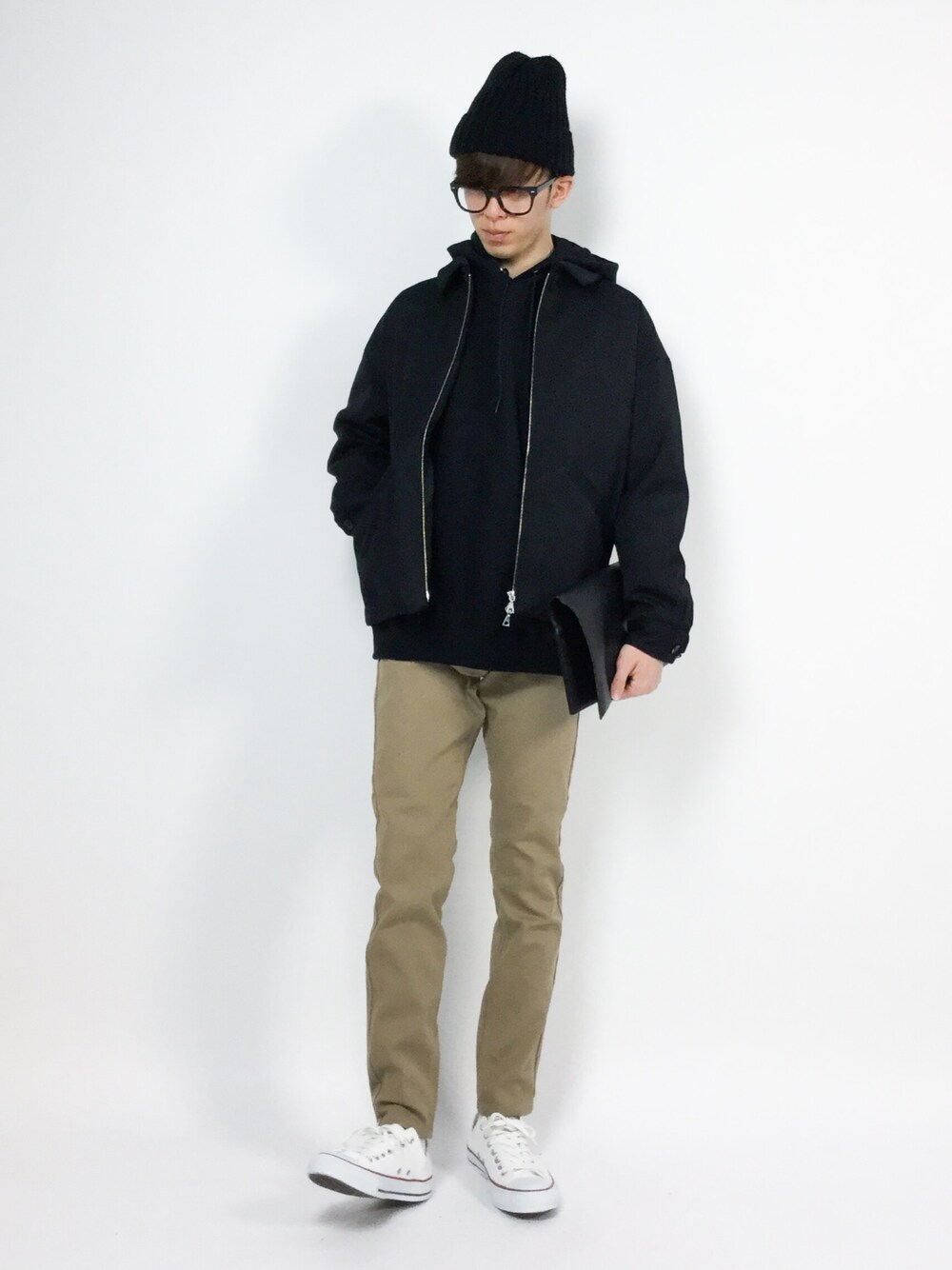ベージュ系のデニムパンツ、ブラック系のブルゾン、ブラック系のパーカーを着用したメンズの冬コーディネートの1枚目の写真