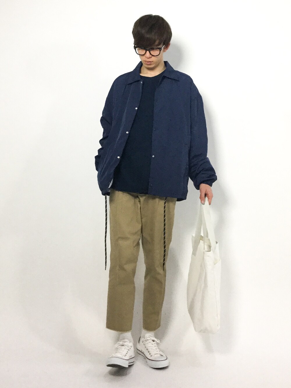 ベージュ系のチノパンツ、ブルー系のナイロンジャケット、ブルー系のスウェットを着用したメンズの冬コーディネートの1枚目の写真